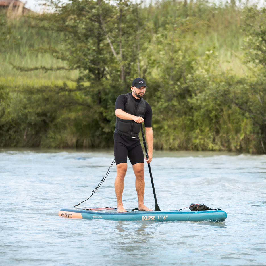 Man on Crivit Eclipse 11'6' paddleboard with life vest and paddle.