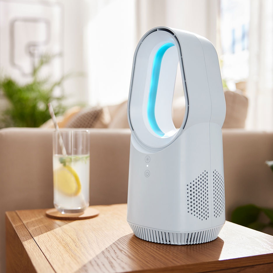 White bladeless fan with blue light on a wooden table with a drink.
