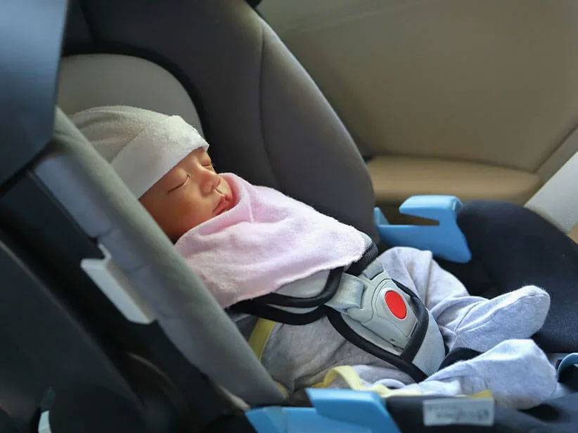Baby sleeping in a car seat.