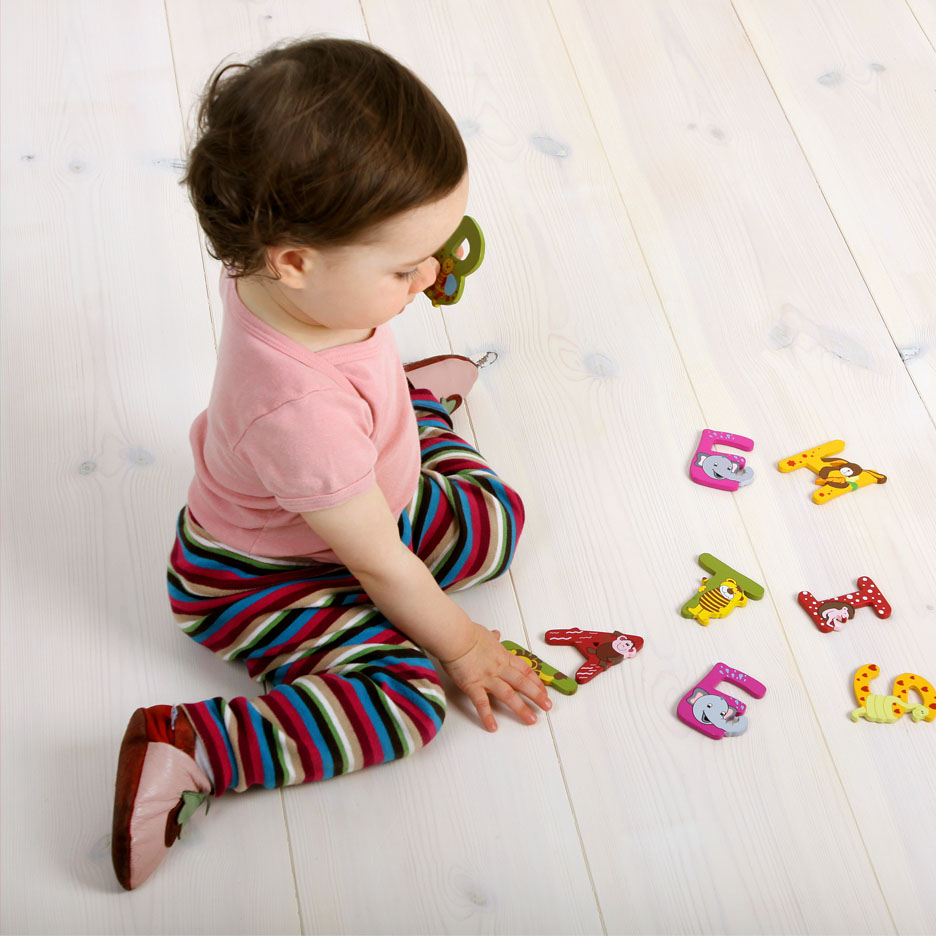 Toddler playing with animal alphabet blocks.