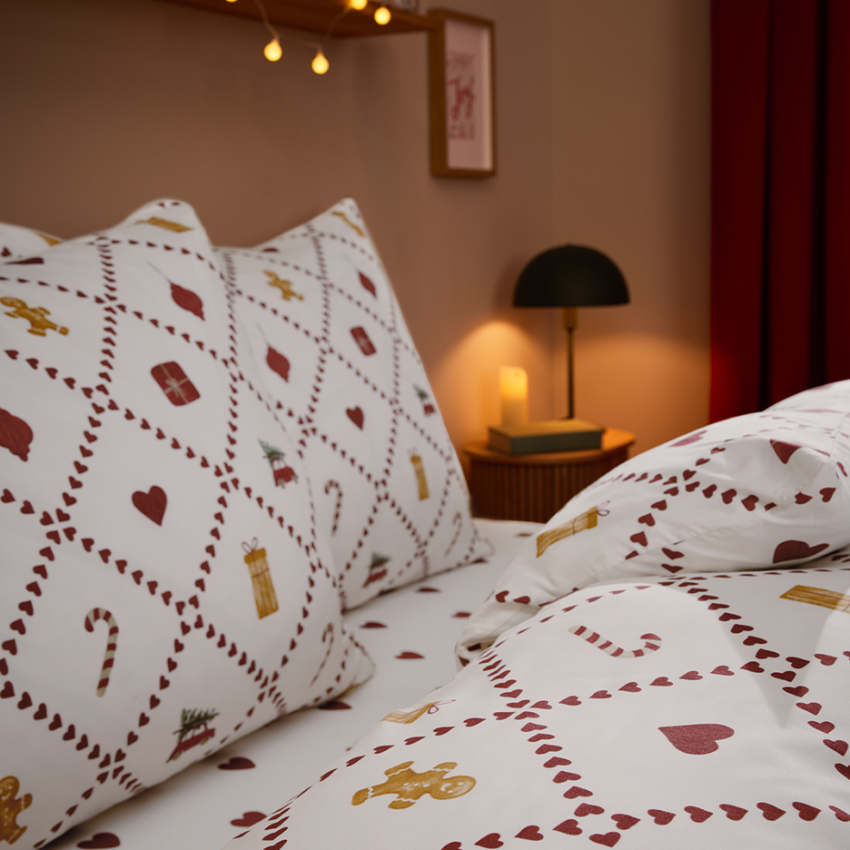 Christmas bedding with gingerbread men and heart patterns in a cozy bedroom setting.