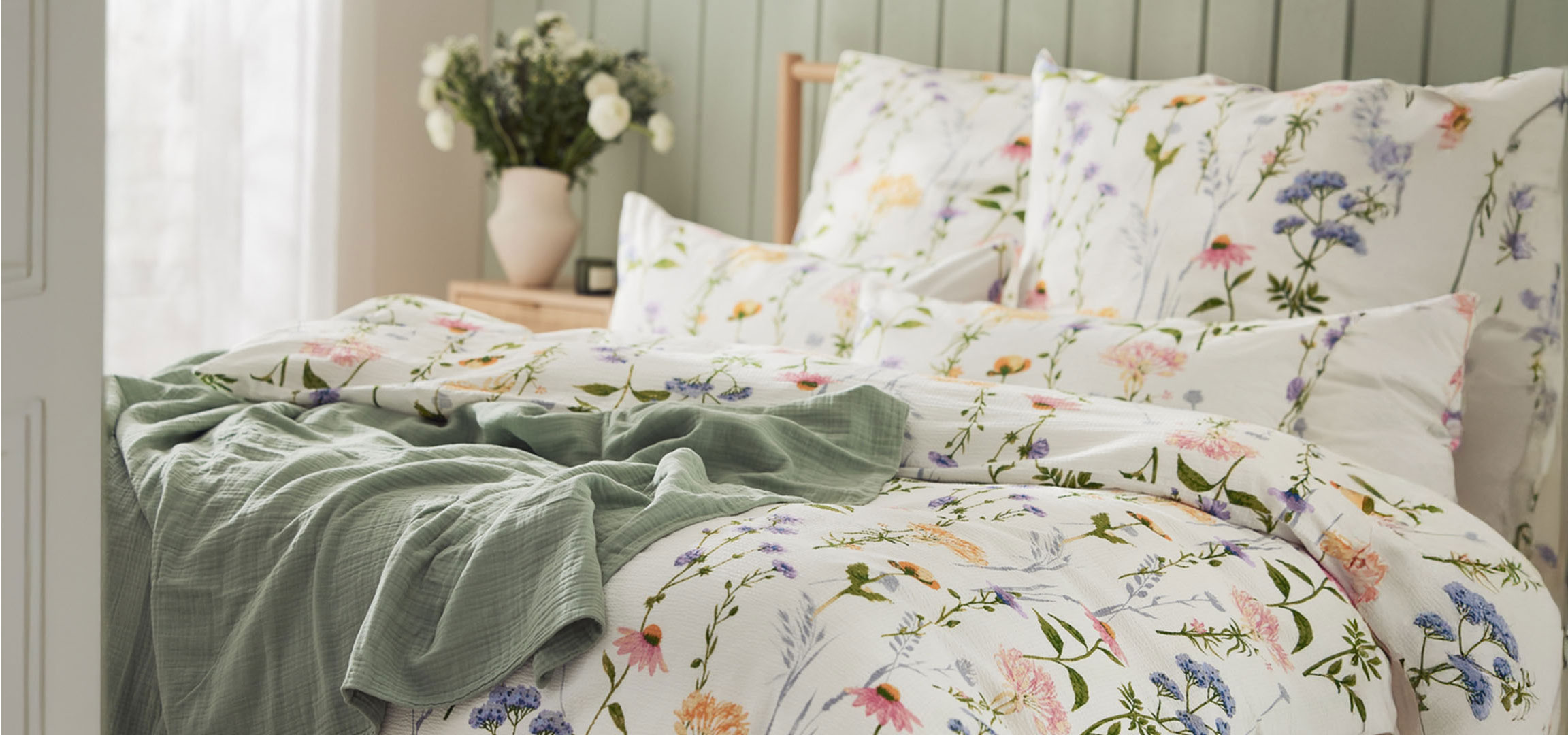 Floral bedding and a throw blanket.
