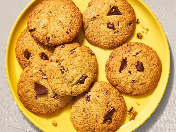 Chocolate chip cookies on a yellow plate.