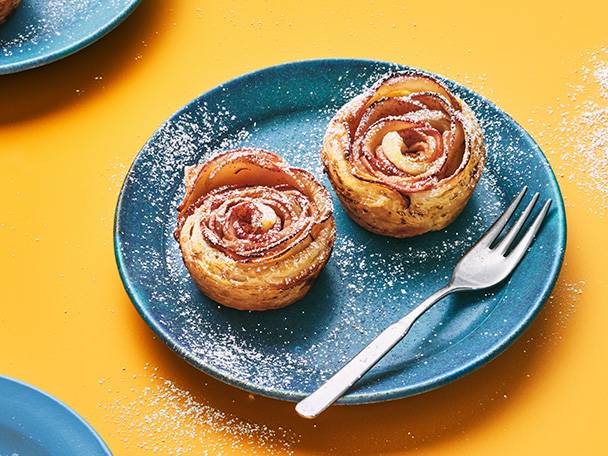 Apple rose pastries on a blue plate.
