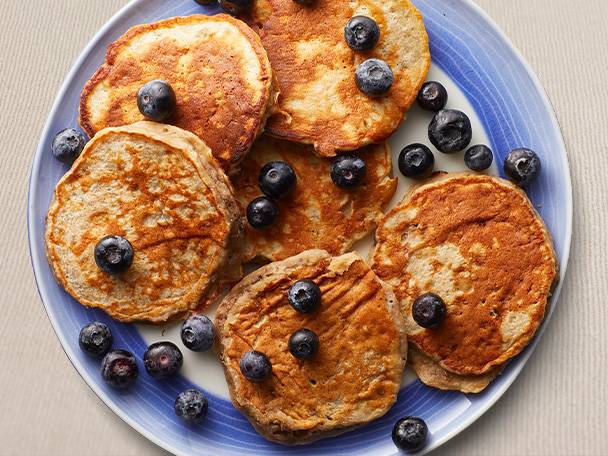 Blueberry pancakes on a blue plate.