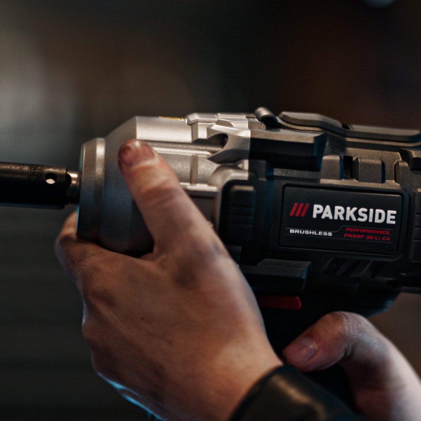 Hands holding a PARKISDE PERFORMANCE cordless impact wrench.