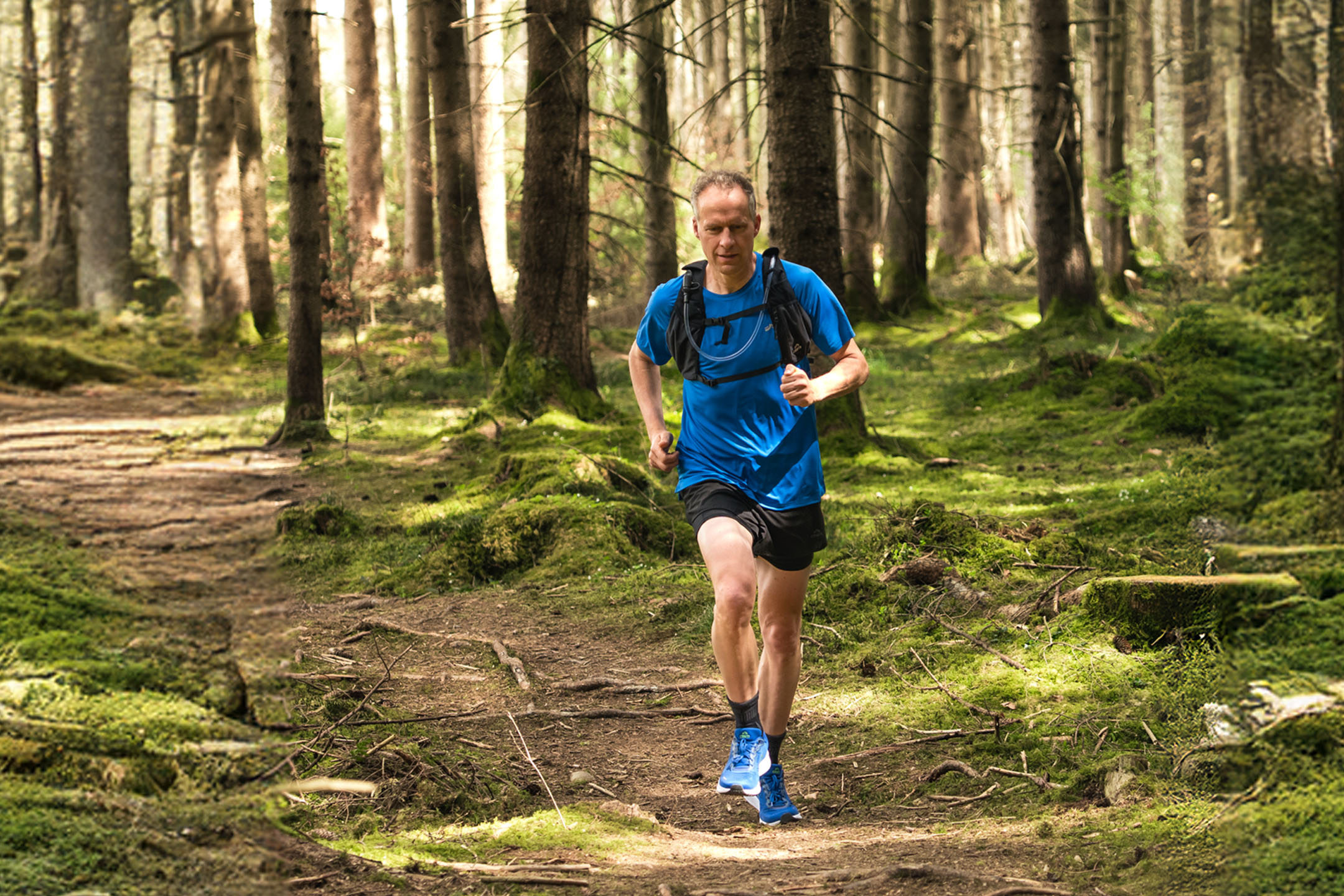 Trail running: man running in a forest.
