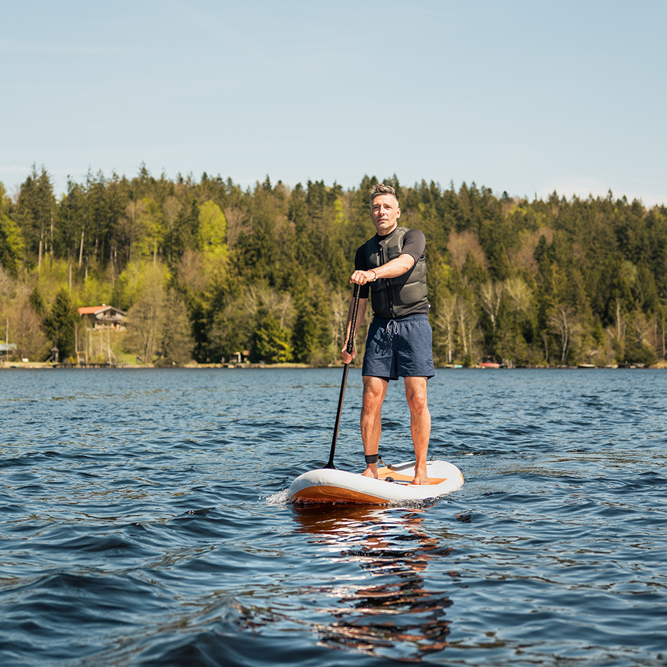 Man paddleboarding on a lake.