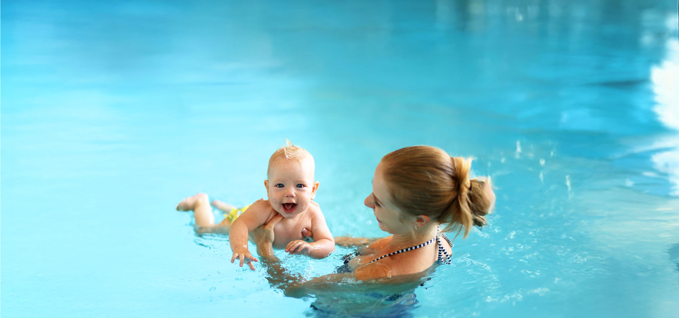 Mother and baby enjoying a swim in the pool.