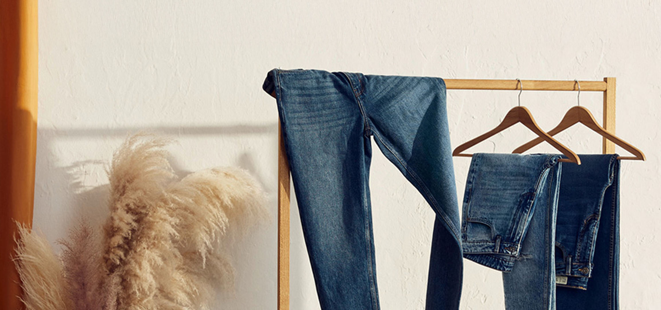 Jeans on a wooden hanger.