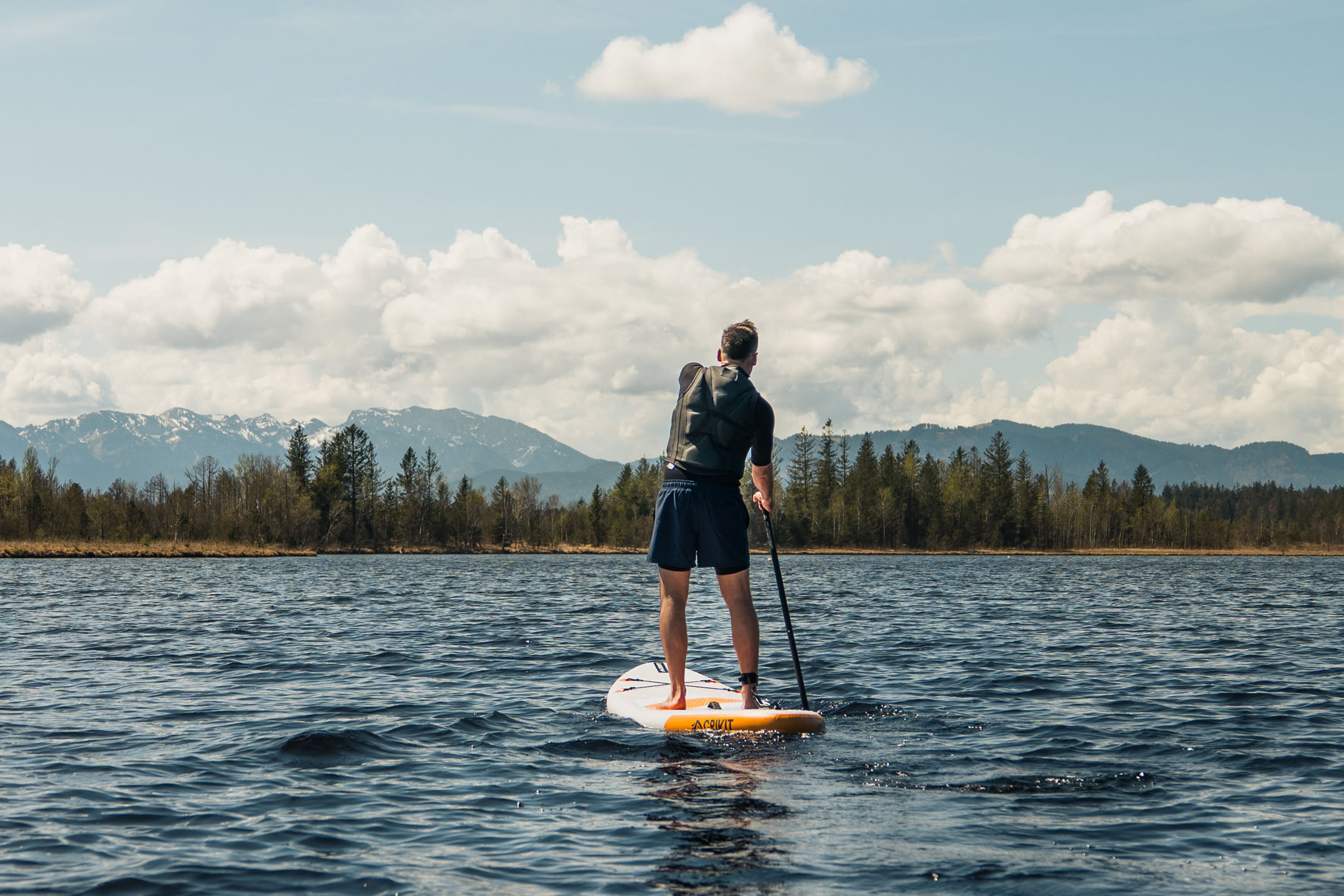 Paddleboarding on a lake with mountains in the background.