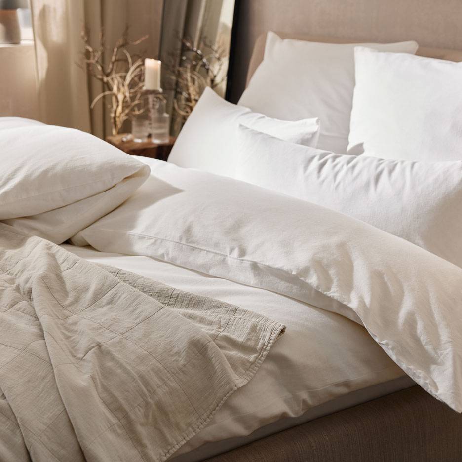 White bedding, pillows, and a throw.